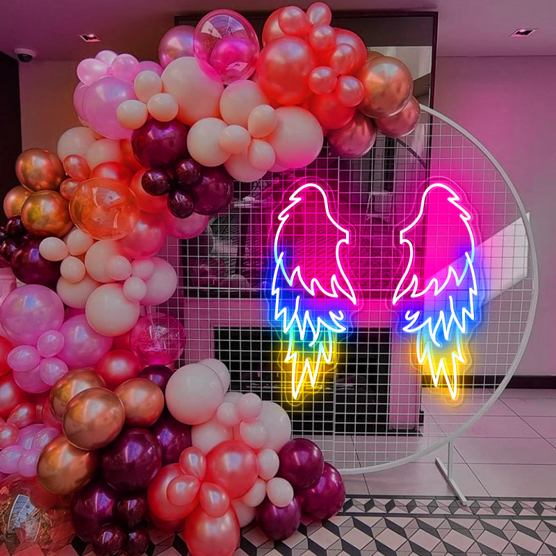 Three coloured Angel Wings LED neon sign installed on a grid backdrop at a birthday event