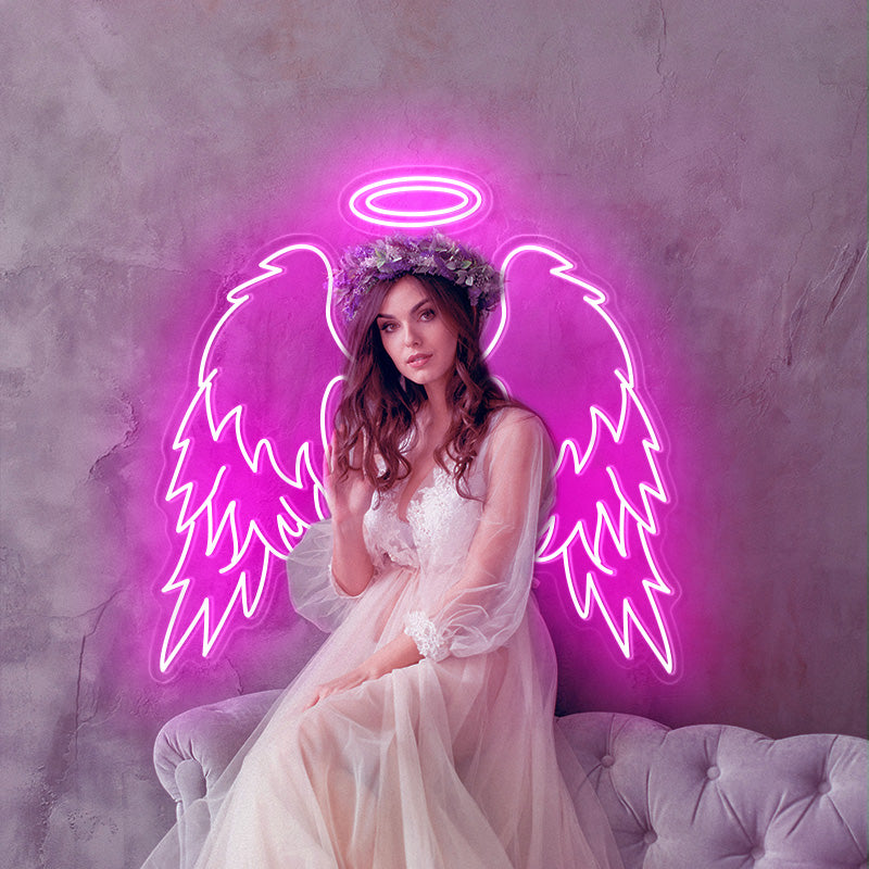 Bride with floral crown in hair in sitting ontop of a couch posing infront of a Deep Pink Angel Wings and Double Halo LED neon sign