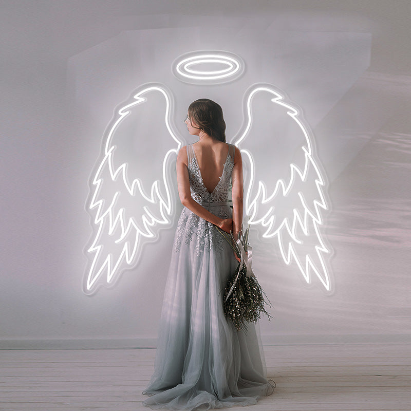 Unique bride in ombre wedding dress posing infront of a large white Angel Wings and Double Halo LED neon sign